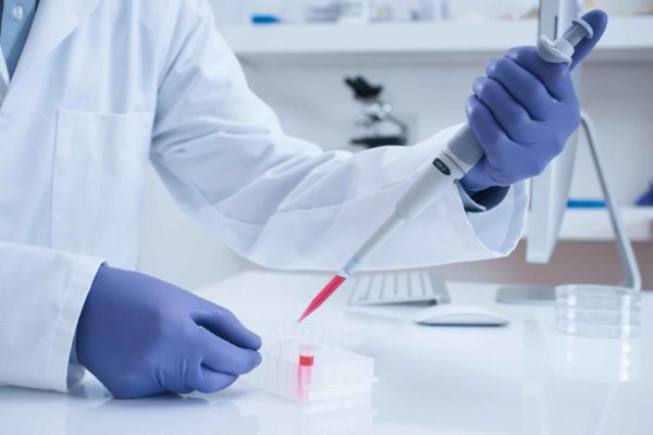 Scientist processing DNA sample in laboratory selective focus